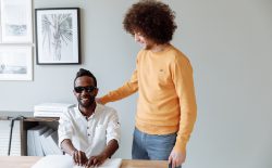 man helping other man to read